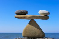 Balanced rocks on a blue sky background to represent gaining life balance through work with psychic Mkuru.